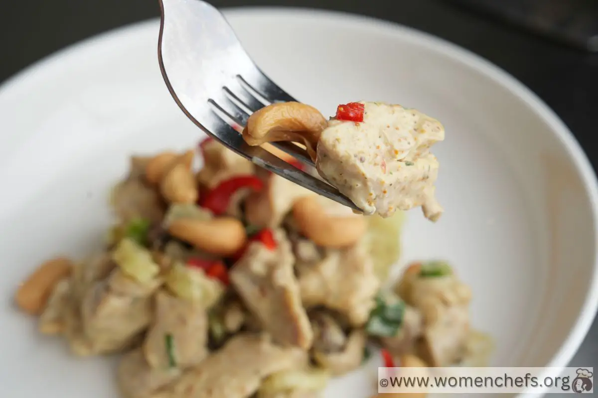 Ina Garten curry chicken salad on a fork with cashew and chilli pepper