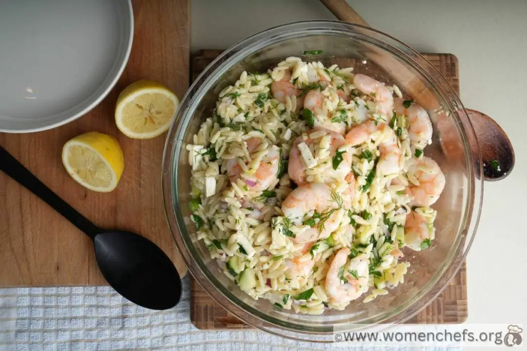 shrimp and orzo salad on a wooden board