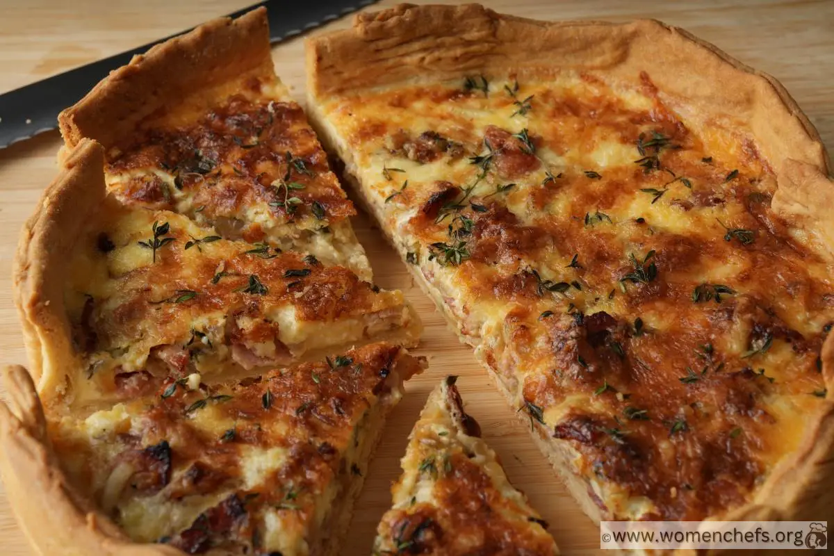 A baked Ina Garten quiche cut into slices on a wooden board