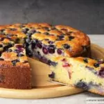 An Ina Garten blueberry ricotta cake being served on a wooden board